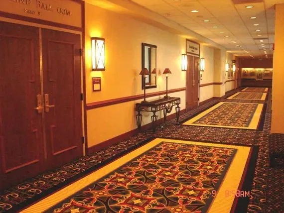 A hallway in a hotel with a carpeted floor.