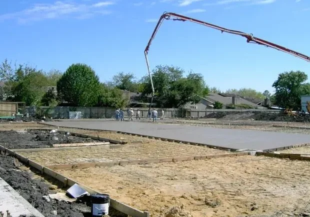 A construction crew pouring concrete on a construction site.